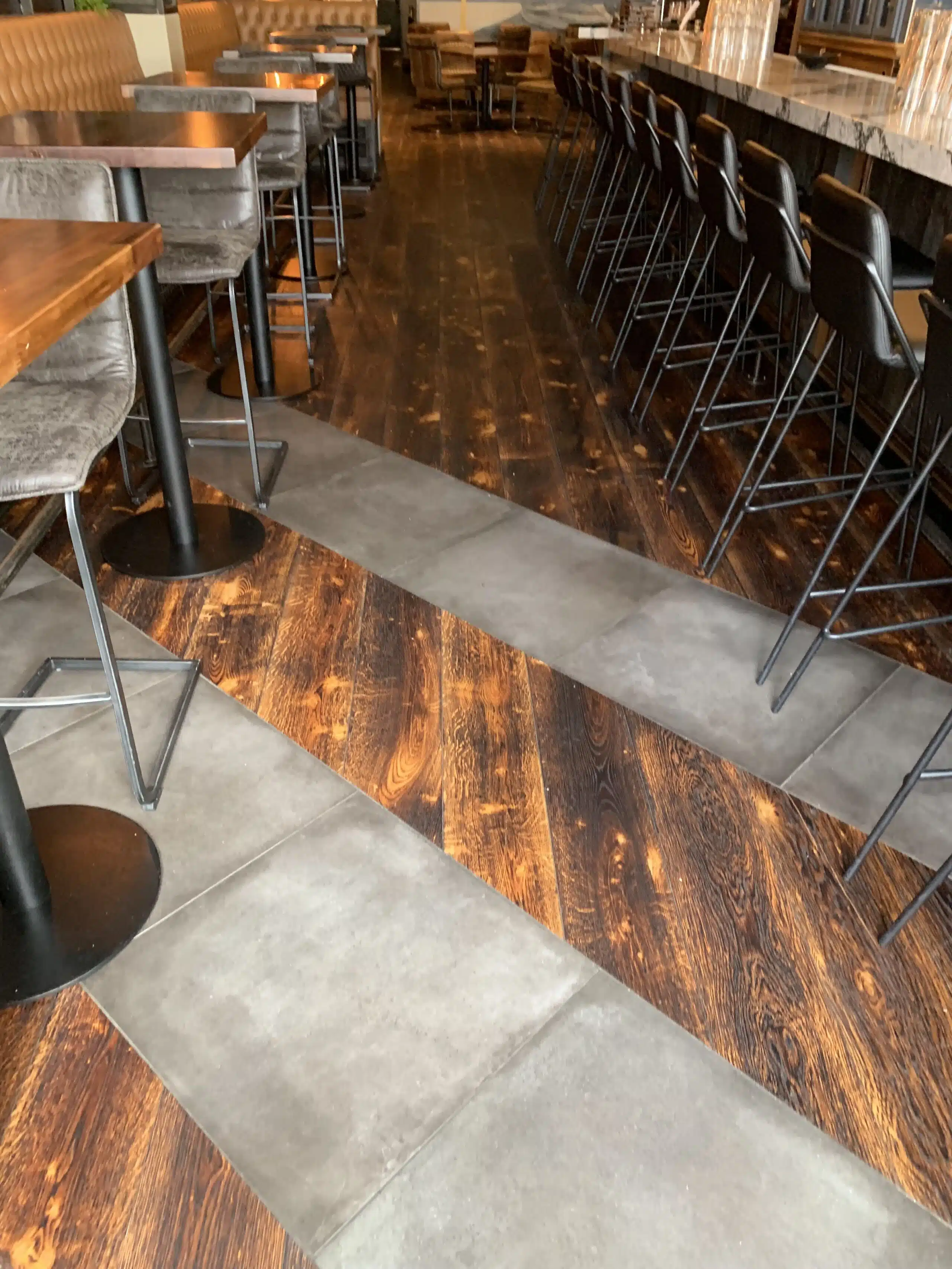 Bar seating area with wood flooring and tile inlay